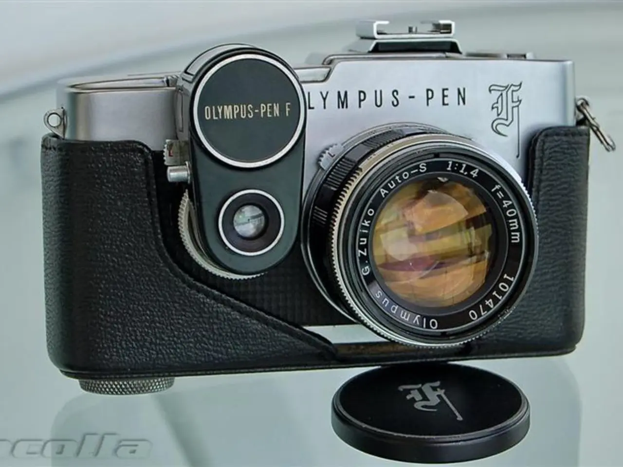 In the image we can see a camera, camera lenses and text on it. On the bottom left we can see the...