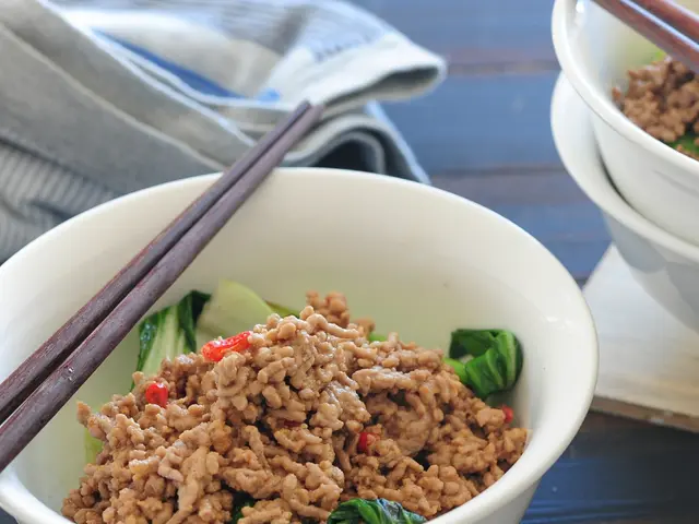 In this image there are food items in the bowls. On top of the bowels there are chopsticks. Beside...