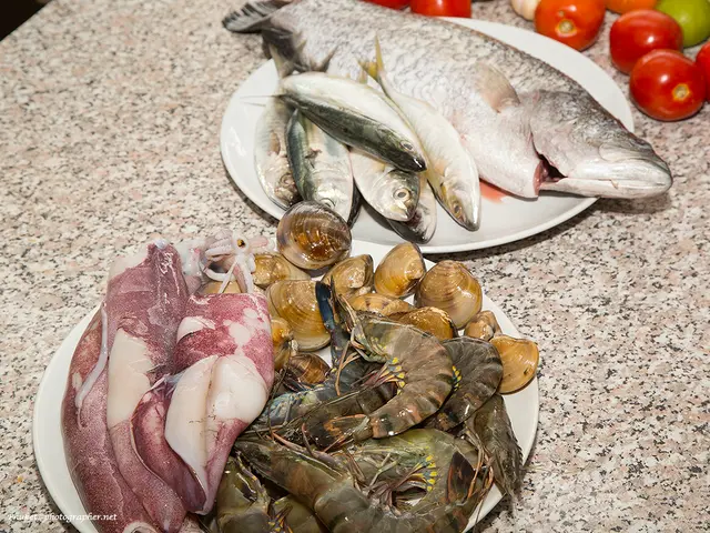 In this image, we can see sea food on the plates and there are some vegetables on the table. At the...