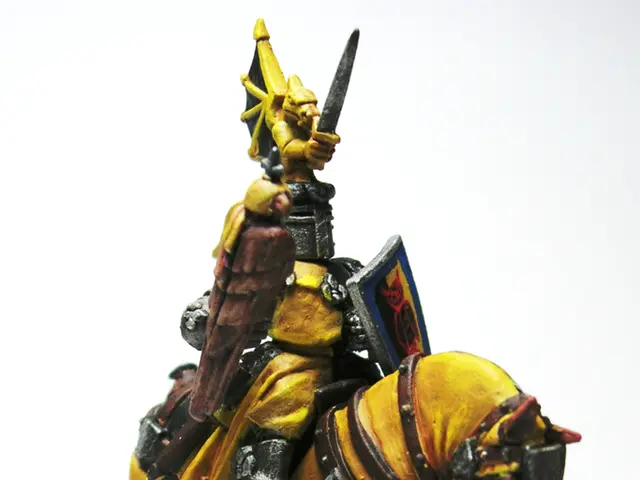 In this image there is a toy sculpture of a man holding a sword and an Armour in the hands and...