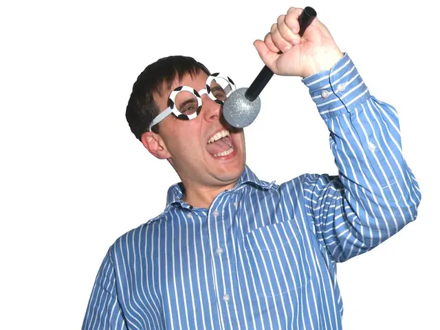 In this picture we can see a man holding a mike in his hand and singing. He is wearing fancy...